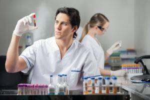 Male technician analyzing blood sample in medical laboratory